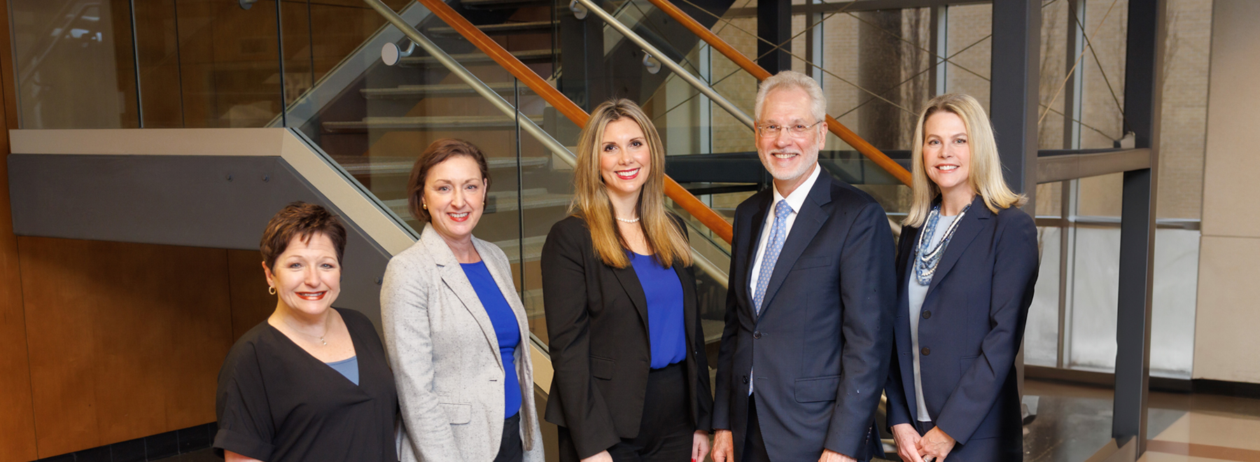 Group picture of five Faculty Affairs staff members in front of a staircase.